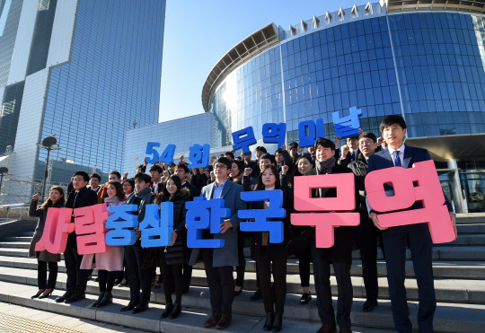'제54회 무역의 날'을 하루 앞둔 4일 서울 삼성동 코엑스 동측광장에서 한국무역협회 임직원과 무역아카데미 교육생들이 올해 행사의 공식 표어인 '사람중심 한국무역'을 들고 기념촬영을 하고 있다.   무역협회 제공